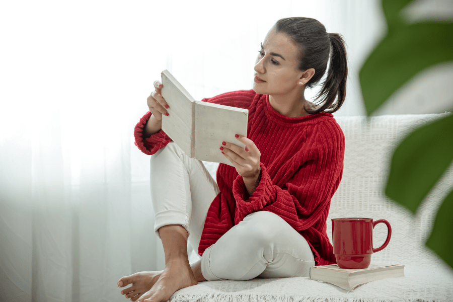 Vrouw rode trui mok boeken over persoonlijke ontwikkeling