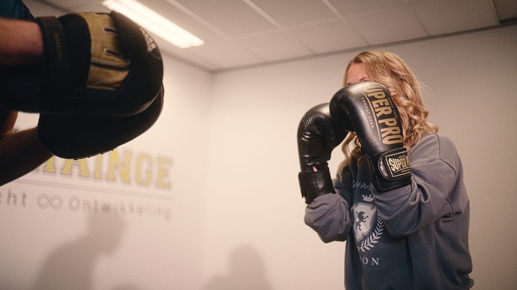vrouw doe omgaan met negatieve emoties door te boksen