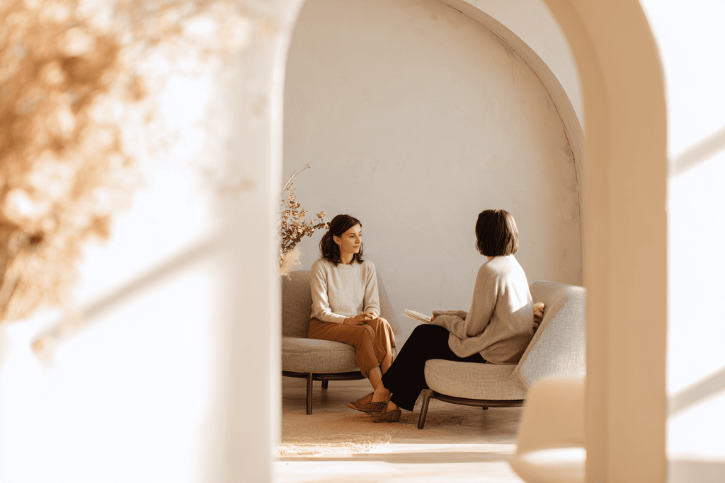 Wat is een transformatie coach? Op deze afbeelding is een transformatie coach in gesprek met een client. 
