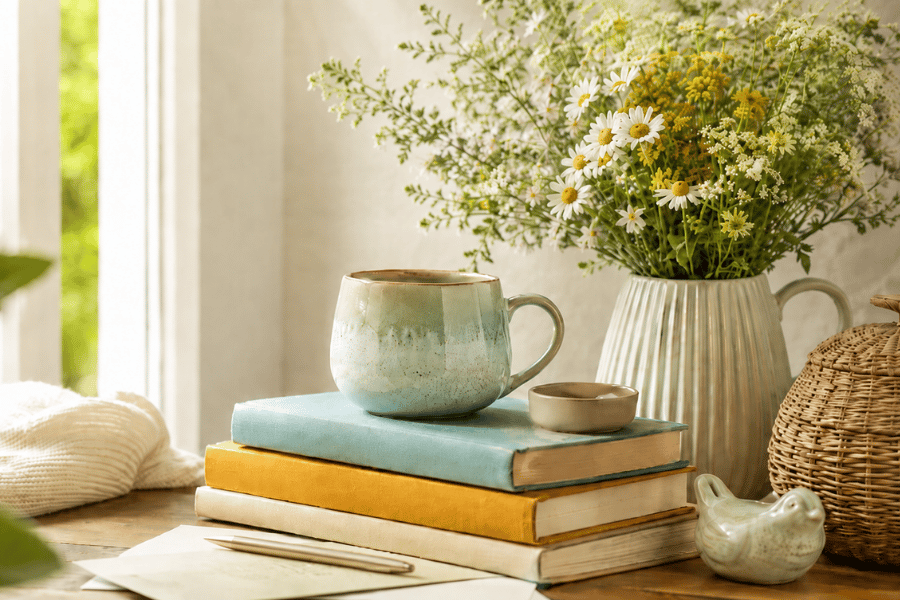Stapel boeken bloemen koffie tafel spreuken pen