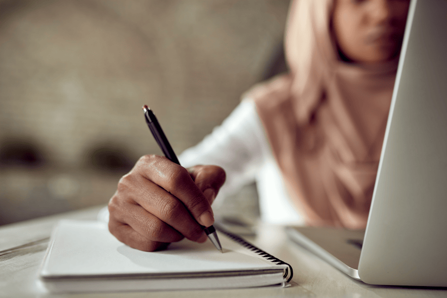 vrouwelijke hand pen schrift laptop schrijven voor mindset en bussiness